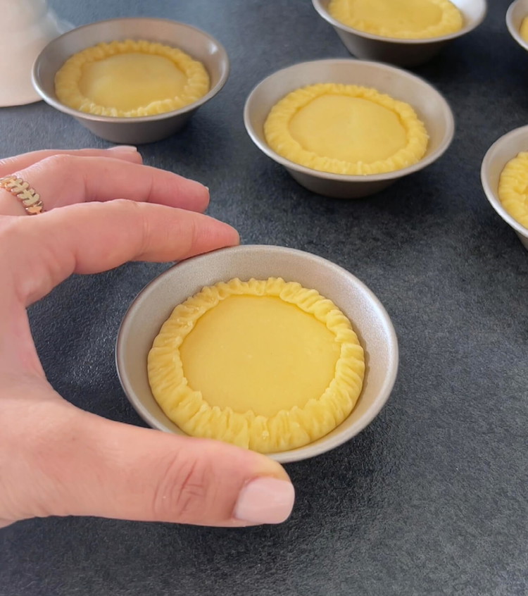 Image of Corta tapas de la masa restante y colócalas sobre el relleno de albaricoque, sellando los pasteles.