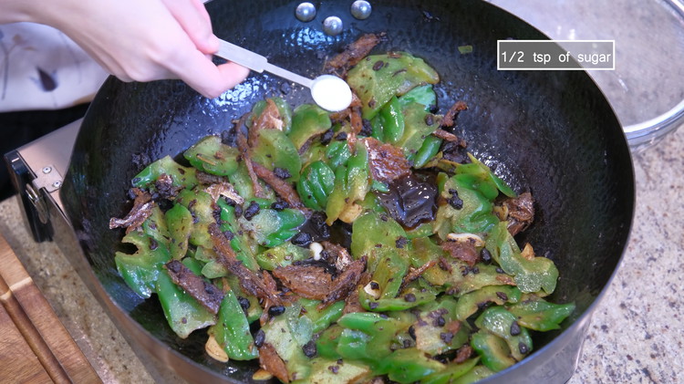 Image of Add the canned fish and drained bitter melon. Season it with oyster sauce, soy sauce, and sugar.
