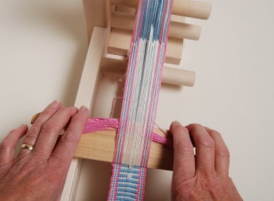 Image of Push the open threads up, white will be up. Weave...