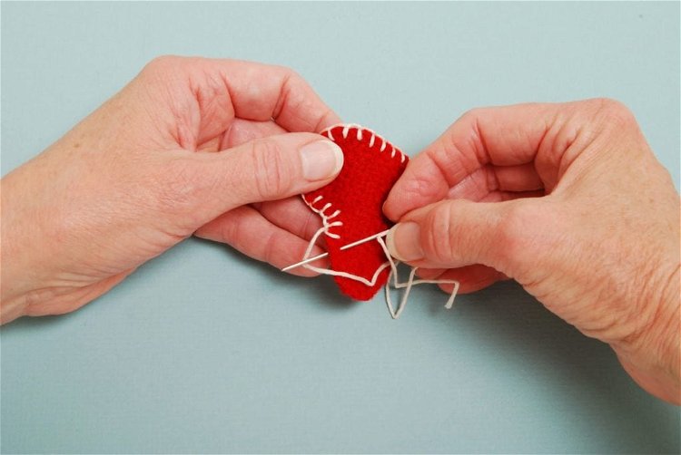 Image of With off-white embroidery floss, trim the outside of the heart...