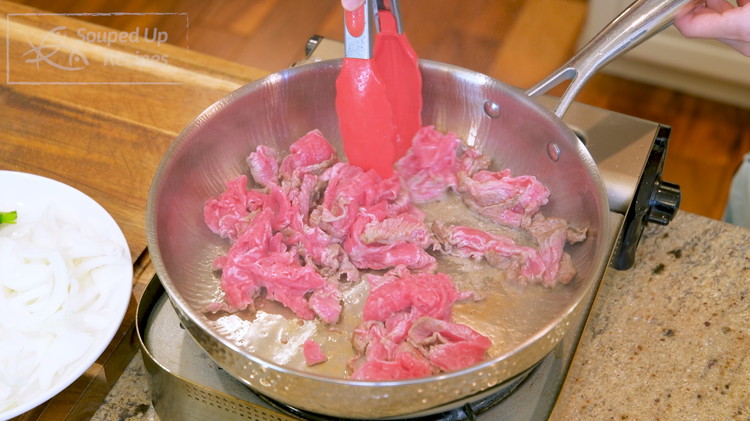 Image of Drizzle in the oil and swirl it around. Add the beef and stir over high heat for a minute because the meat is thinly sliced and we don’t want to overcook it.