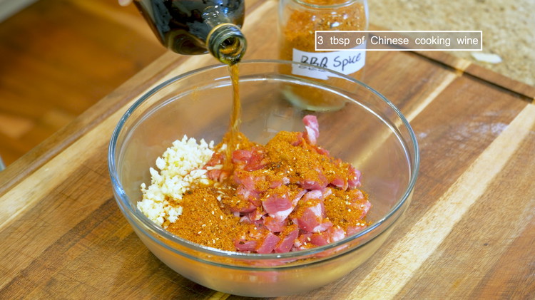 Image of In a big mixing bowl, add 1 lb of ground or diec pork, 4 tbsp BBQ spice, 2 tbsp of minced garlic, and 3 tbsp of Chinese cooking wine and mix well.