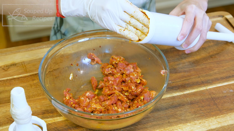 Image of Just twist the handle to push the meat into the casing. Once the sausage has reached the length you want, give it a little squeeze and tie it with kitchen twine.