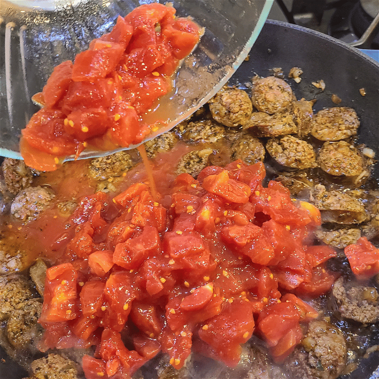 Image of Return the sausage to the pan with the diced tomatoes...