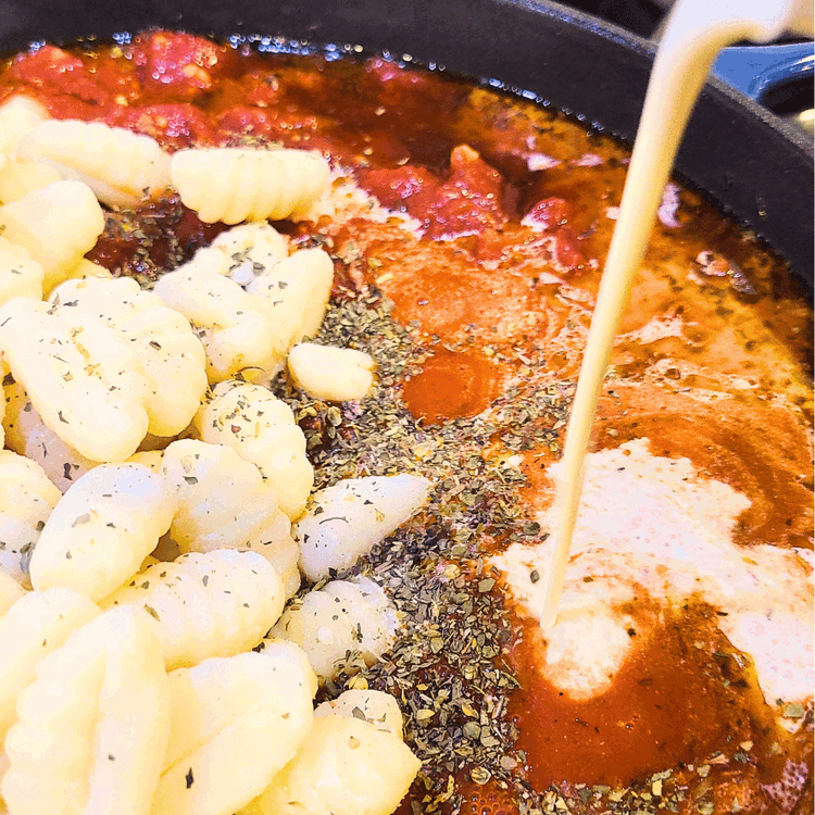Image of Add uncooked potato gnocchi, heavy cream, and tomato sauce to the skillet