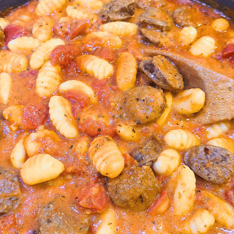 Image of Stir well to combine, ten bring the mixture to a boil on medium heat, stirring everything well. Cover the skillet with a lid and allow the gnocchi to cook for 5 minutes while the sauce boils.