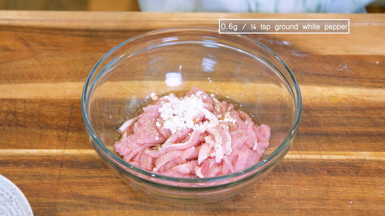 Image of Marinade the pork with 1 tbsp soy sauce, 1 tbsp Chinese cooking wine, 1.5 tsp cornstarch, and 0.6g / ¼ tsp ground white pepper and mix well.