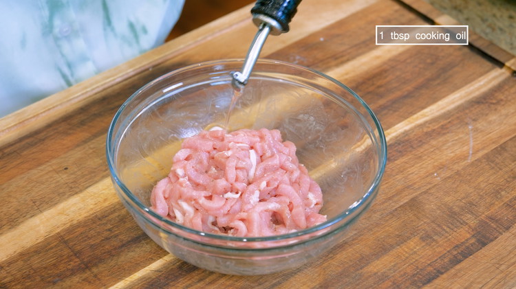 Image of Coat the pork with 1 tbsp cooking oil, preventing the meat strips from tangling together and making it easier to stir fry later.