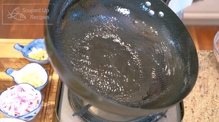 Image of Turn the heat to high and heat the wok until smoking hot. This is the trick to prevent food from sticking to the pan. Drizzle a generous amount of oil and swirl it around to create a non-stick layer.