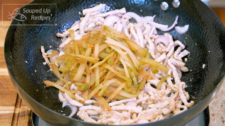 Image of Add minced ginger, garlic, shallot and stir until fragrant. Add the julienned zhacai, and red chili. Continue to stir over high heat for 2-3 minutes.