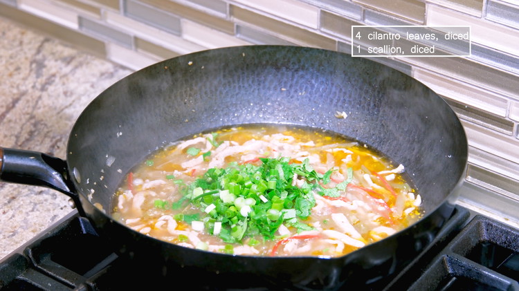 Image of Add the zha cai and the shredded pork, which has been simmering for 10 minutes now. Toss in some diced cilantro and scallion.