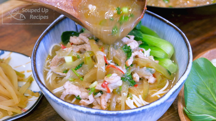 Image of To make a serving, add one portion of noodles to a big serving bowl. Place the bok choy on the side and pour the zhacai pork along with the broth into the serving bowl.