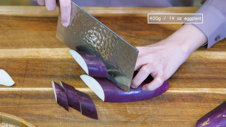Image of Cut the eggplants in half, lengthwise. Then, slice them diagonally into 2/3-inch thick pieces. I like to use long, skinny Chinese eggplants because they are tender, but other kinds will also work.