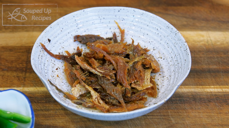 Image of Open one can of fried dace. Break the fish meat into bite size pieces. Reserve the fermented black beans and oil on the side.