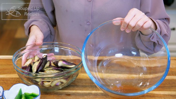 Image of After 15 minutes, the salt has drawn out some moisture from the eggplant. Squeeze to eliminate the water as much as possible.