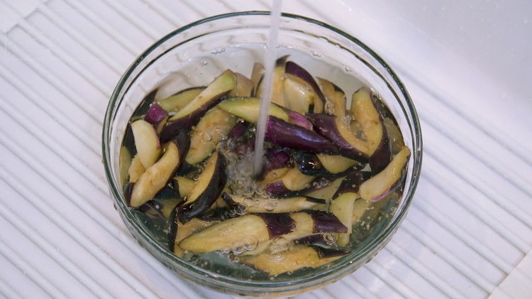 Image of Quickly rinse the eggplants under running water to remove the excess salt. Squeeze it again to get rid of the excess water.