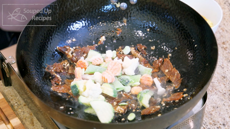 Image of Add 1.5 cups of frozen vegetables straight from the bag without defrosting and stir over medium-low heat for 2-3 minutes or until the vegetables are cooked. Please don't use high heat at this point because the fried dace is deep-fried...