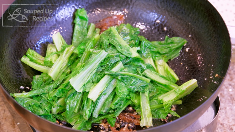 Image of Toss in the lettuce and switch to high heat. Continue to stir for one more minute. If you use low heat to cook leafy vegetables, they will produce a lot of moisture and dilute the flavor of the dish.