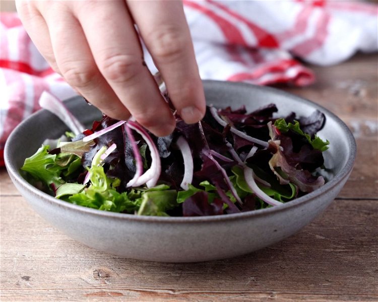 Image of In a large bowl, combine the mixed baby greens, slivered...