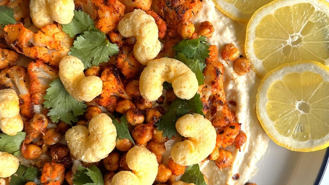 Close up of roasted cauliflower and chickpeas with feta, decorated with lemons