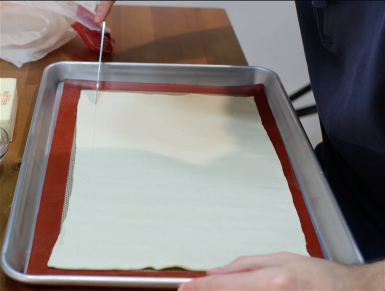Image of Unroll the puff pastry on the parchment paper. Flatten it...