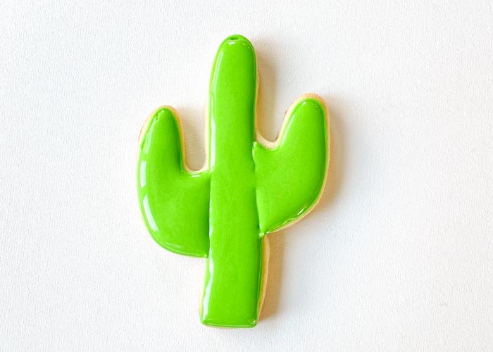 Image of Fill the other arm of the cactus with green flood consistency icing. Use a scribe tool or toothpick to move the icing around, ensuring full coverage and getting rid of any air bubbles.