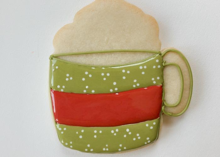 Image of Once the green icing is dry, flood the center strip of the mug with red flood consistency icing. Move the flood icing around with a toothpick or scribe tool to ensure full coverage and to remove any air bubbles.