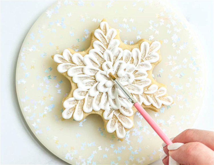 Image of Using the paintbrush, brush each dot into the center of the cookie. At this point, we should be in the center of the cookie and have a completely covered cookie.