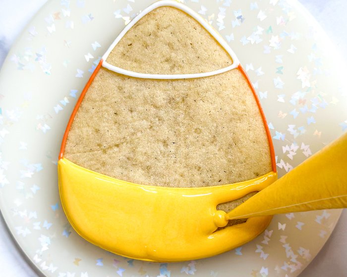 Image of Fill in the bottom third of the cookie with yellow flood consistency icing as shown.