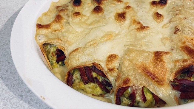 A plate of pancakes, wrapped and baked enchilada-style
