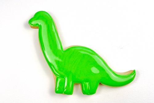 Image of Fill in the body of the beast with flood-consistency green icing. Use a scribe tool or toothpick to move the icing around to ensure full coverage.