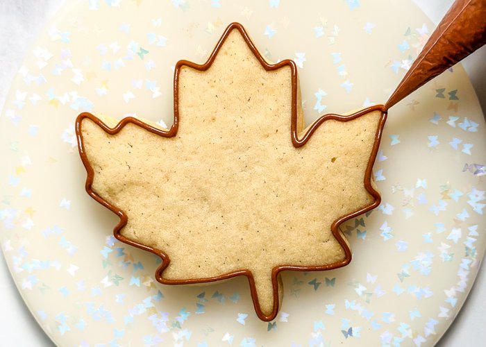 Image of Using the brown piping consistency icing, outline the entire leaf shape. The next steps need to be performed one right after the other, so read ahead and make sure that all of your icing is ready before moving on to the next step.
