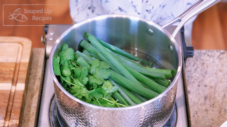 Image of Add 2 cups of oil, scallion stalks, cilantro leaves, purple onion, and ginger slices to a pot. I am using peanut oil, but any high smoke point vegetable oil will work well for this recipe, such as soybean, corn, and...