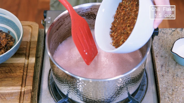 Image of Add raw sesame seeds and red chili flakes. Then, turn off the heat immediately so you don't burn anything. Make sure the chili flake fits your spice tolerance. If your sesame seeds are toasted already, please add them at the...