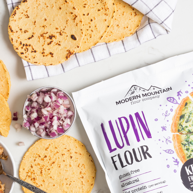 A pile of keto-friendly tortillas next to a pouch of Modern Mountain Lupin Flour