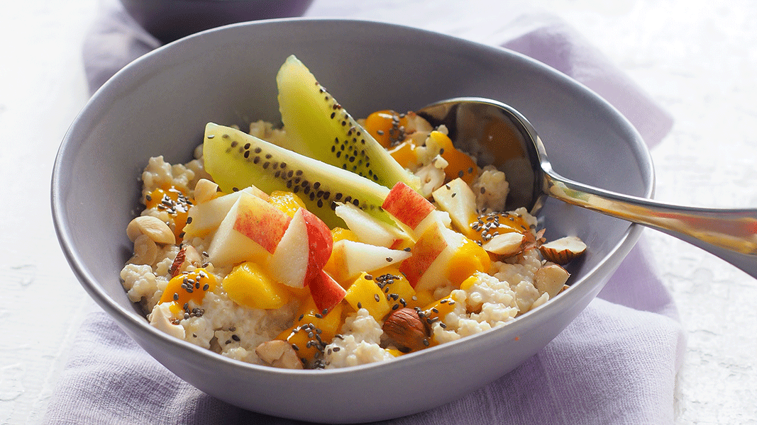Image of Hirse-Porridge mit Cashewmus-Sahne, frischen Früchten und Mango-Topping