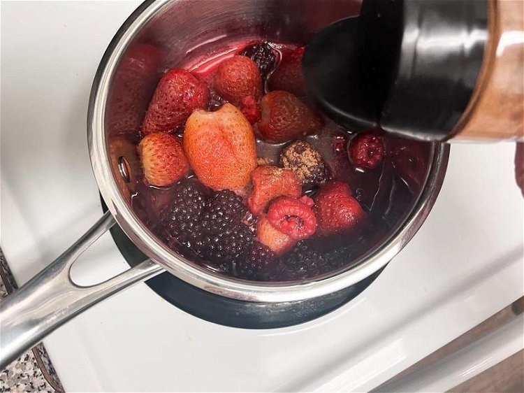 Image of While the pancake is baking, add mixed berries and maple...