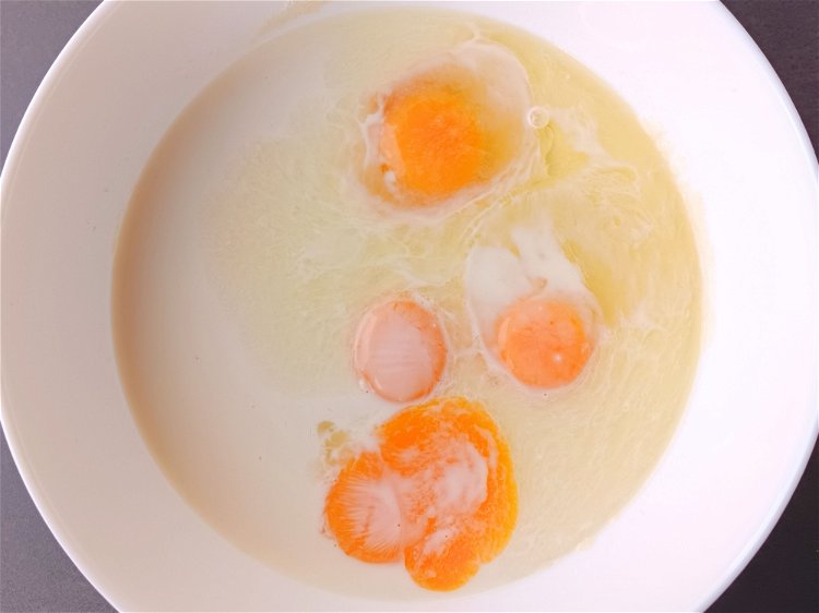 Image of Ajouter deux jaunes d’œufs et les deux œufs entiers.