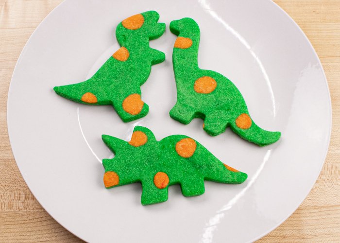 Image of These sweet dino cookies take literally no (zero, zilch, nada) cookie decorating experience to make, and they are so colorful & beautiful on their own! Eat them plain or serve them with a dunking cup of icing at your next kid's party or dinosaur-themed event!