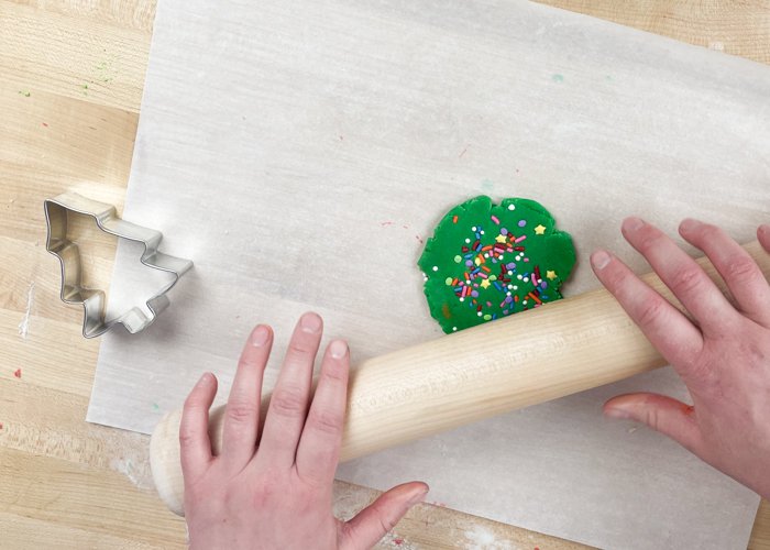 Image of You can choose to either cut out your holiday shapes at this step & bake, or you can add sprinkles to your dough. If adding sprinkles, spread them around the dough, and then roll the dough until they are incorporated into the green dough base.