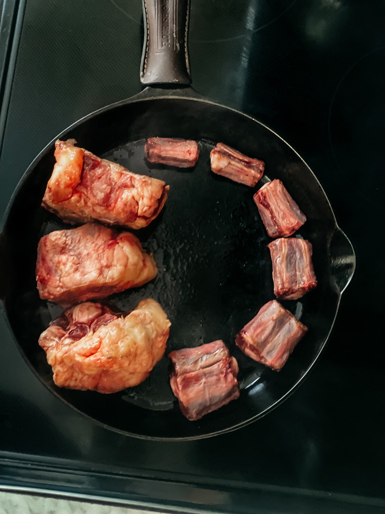 Image of Sear the oxtail on all sides until browned. Transfer to the slow cooker.