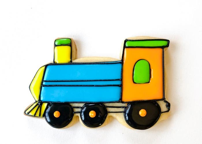 Image of Once the body of the train is crusted over, begin adding details with black piping consistency icing as shown. Connect the wheels and add detail to the cow-catcher.