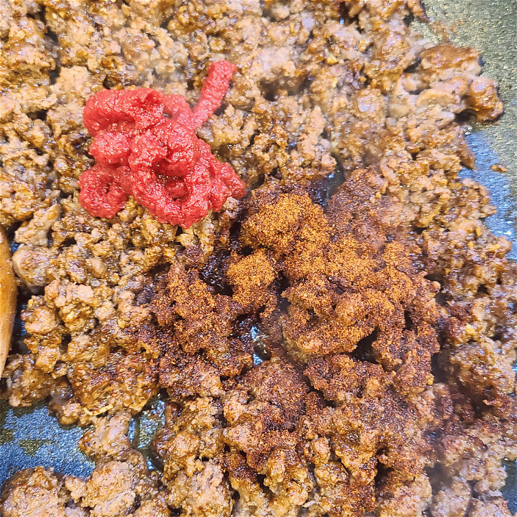 Image of Stir in the taco seasoning, tomato paste, and water. Simmer...