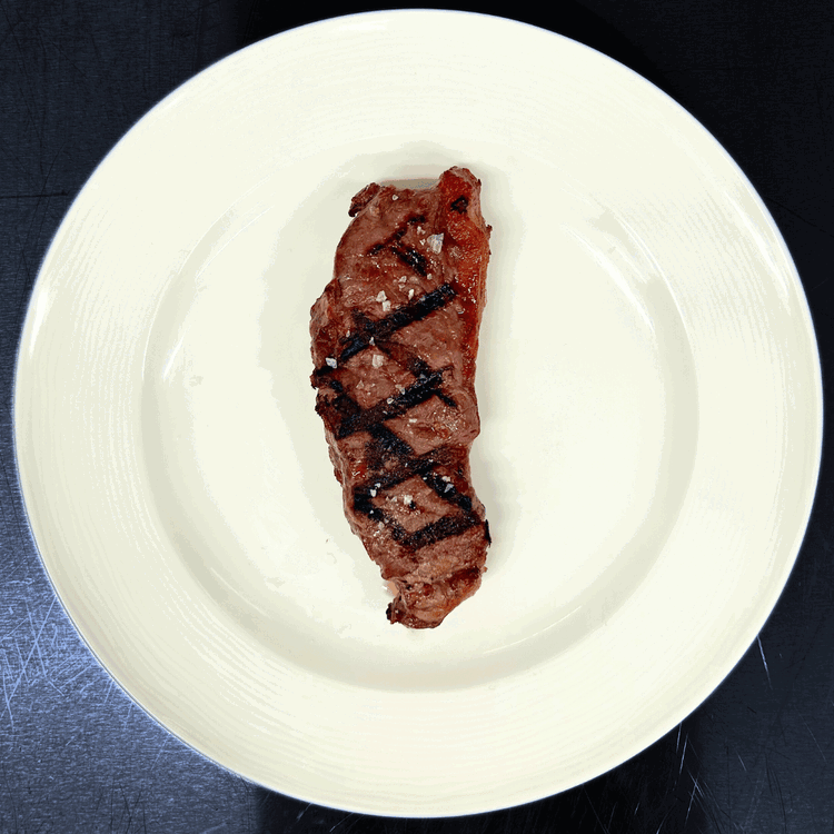 Image of The resting period is crucial for this cut. After the grilling process, allow the Bison New York Strip to rest for a minimum of 8 minutes. The fat's unique placement means that heat transfer occurs more gradually compared to fattier...
