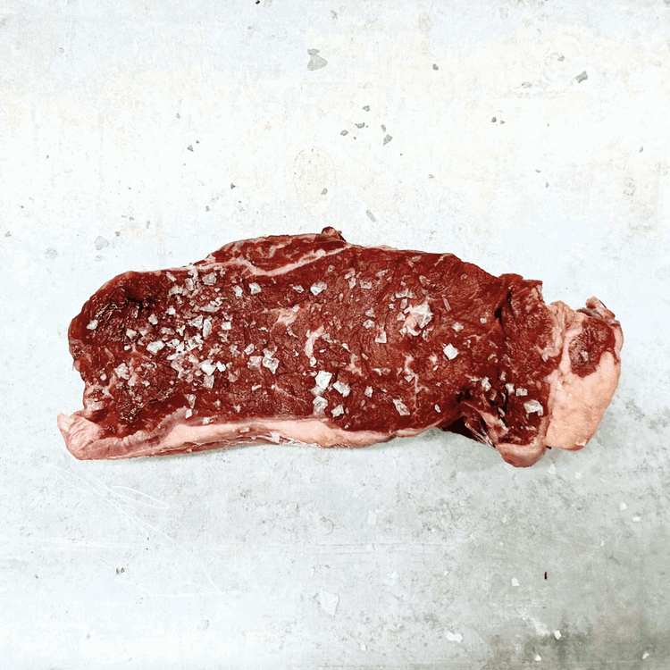 Image of While the grill is heating, take your steak out and pat it dry with a paper towel. Season both sides generously with a simple yet effective combination of salt and pepper.