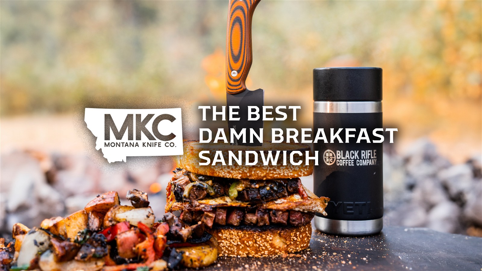 A hearty steak-and-egg breakfast sandwich sits outdoors on a clean slab, stabbed through with an MKC knife.