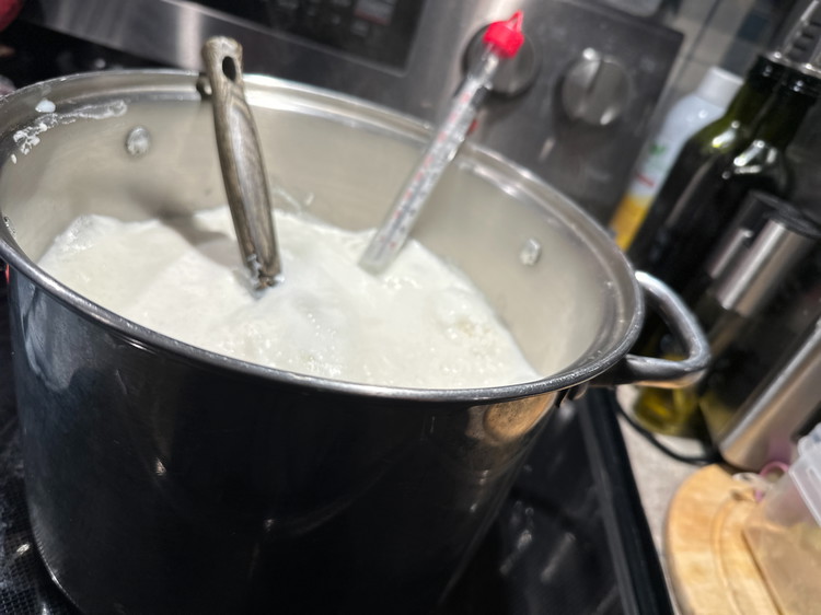 Image of With a wooden or metal spoon, stir your milk very slowly and consistently in a side-to-side motion (This is the trick to getting fluffy, beautiful curd, not a grainy sand-like texture in store-bought).  This also keeps the milk from sticking...