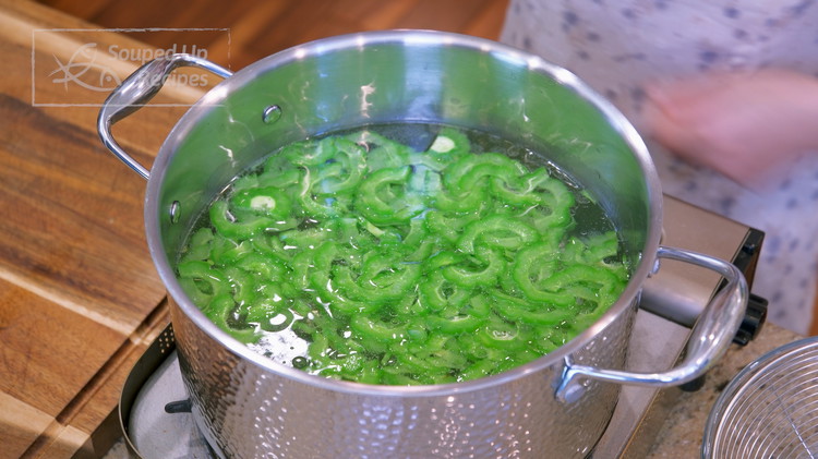 Image of Bring a pot of water to a boil and drizzle in 1.5 Tbsps vegetable oil. Add the bitter melon slices and let it blanch for 30 seconds. Blanching also helps to reduce the bitter taste.