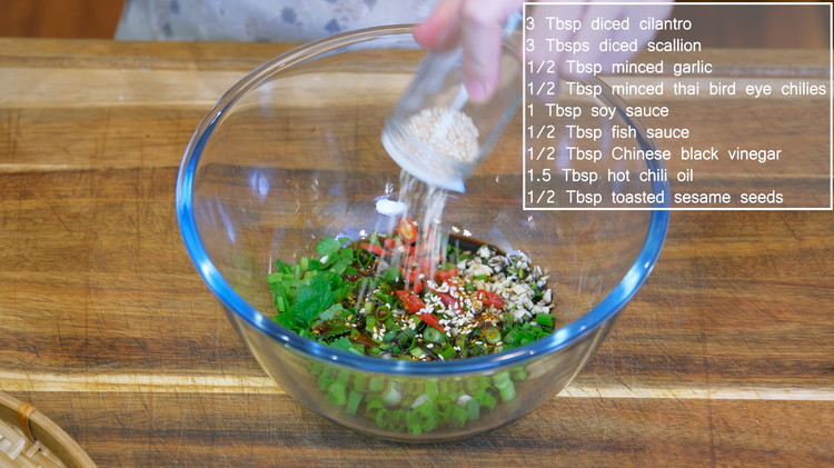Image of While waiting, combine the diced cilantro, scallion, minced garlic, thai bird eye chilies, soy sauce, fish sauce, Chinese black vinegar, hot chili oil, and  toasted sesame seeds in a mixing bowl.