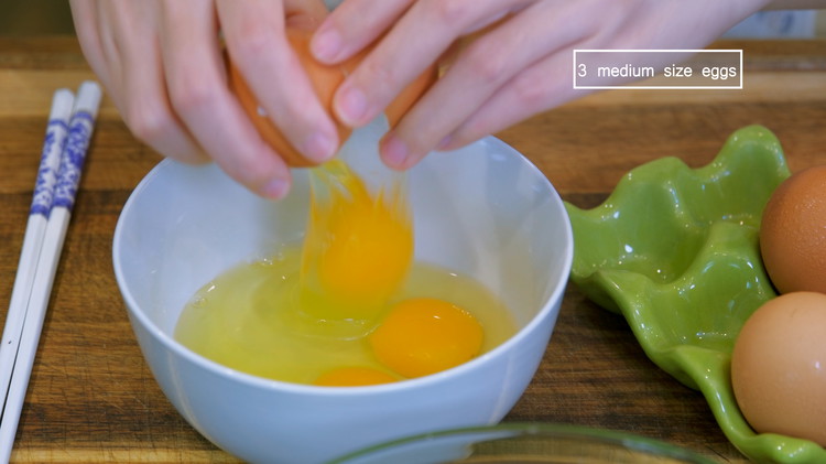 Image of While waiting, mince 5 cloves of garlic. Crack 3 eggs into a bowl and beat them well.